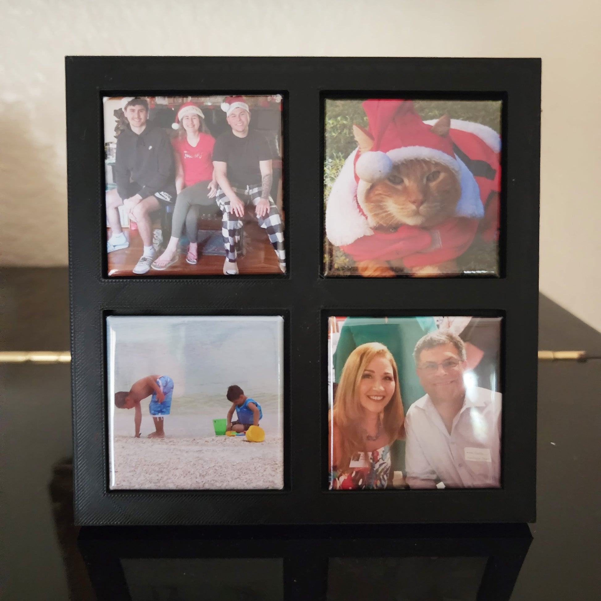 close up of black magnetic frame holding four photo magnets