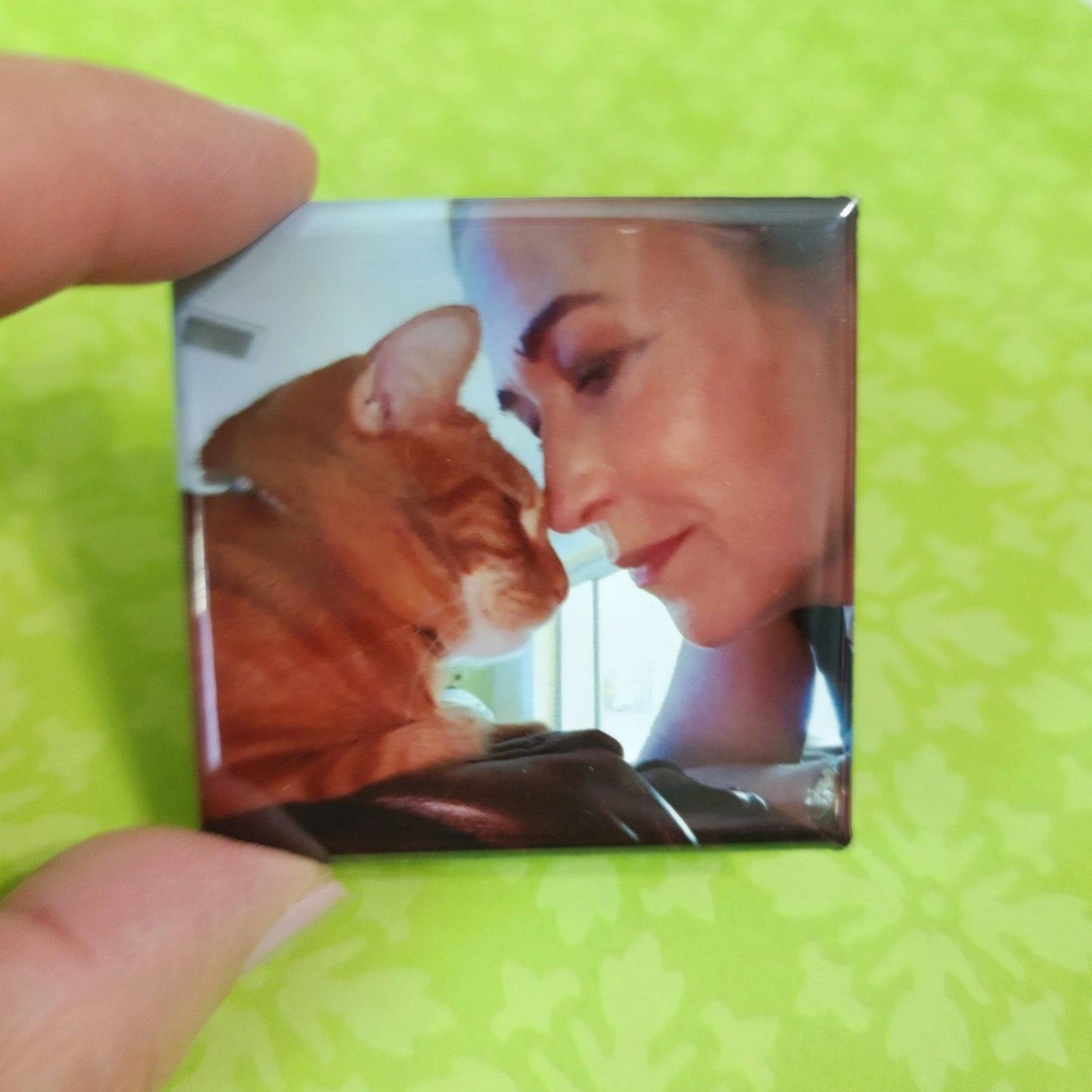 Small square magnet with a woman and cat rubbing noses on a green background